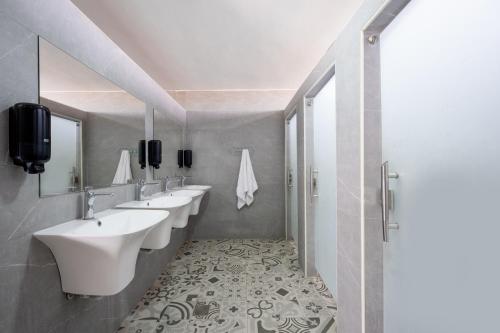 a bathroom with a row of sinks and mirrors at Camp Sahara in Kalia