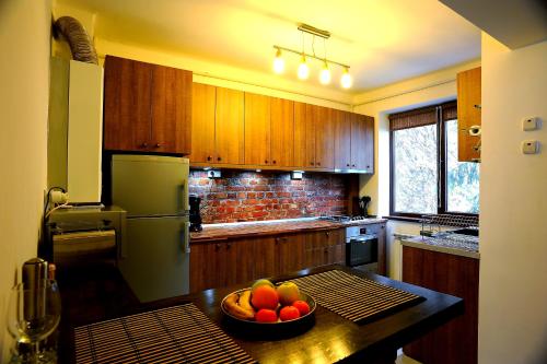 a kitchen with a bowl of fruit on a table at Apartament Downtown Cluj-Napoca in Cluj-Napoca