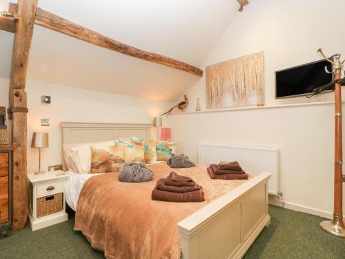 two beds in a bedroom with a tv on the wall at Palace Studio in Hereford