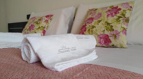 einen Stapel Handtücher auf dem Bett in der Unterkunft Sunset View Treviso Apartment in Treviso