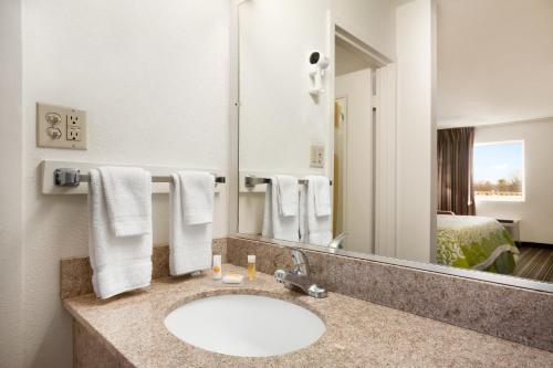 a bathroom with a sink and a large mirror at Days Inn by Wyndham Shelby in Shelby