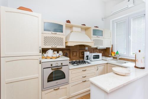 a white kitchen with a stove and a refrigerator at Villa Marini Dvori - with free parking in Dubrovnik