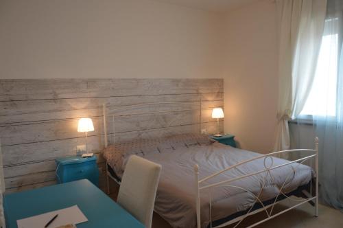 a bedroom with a bed with a wooden headboard at Salice ottimo trilocale con terrazza pranzabile in Marina di Castagneto Carducci