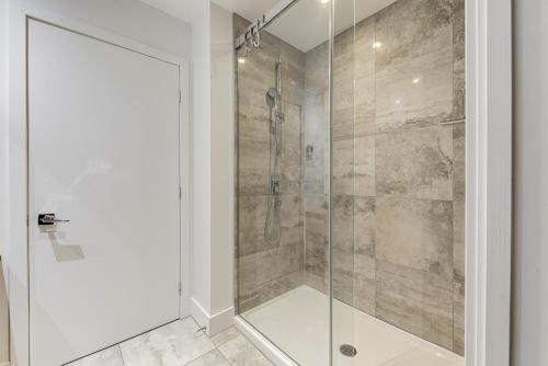 um chuveiro com uma porta de vidro na casa de banho em Les Immeubles Charlevoix - Le 760207 em Cidade de Quebec