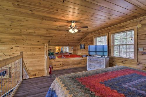 a log cabin bedroom with a bed and a television at Gatlinburg Cabin with Pool Table and Hot Tub! in Gatlinburg