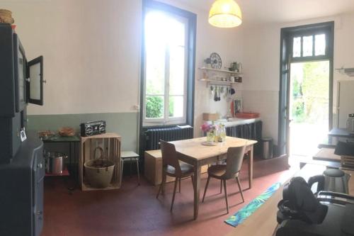 a dining room with a table and chairs in a room at La Ptite Fabrique chez Malot in Montceau-les-Mines