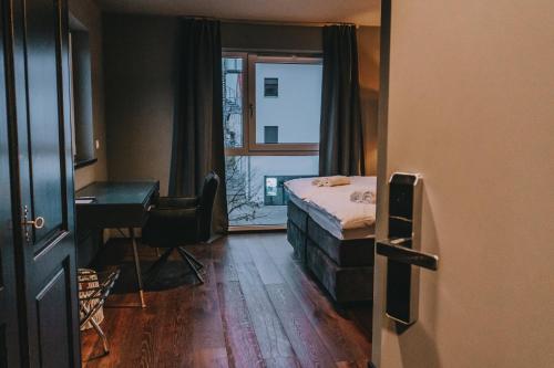 een slaapkamer met een bed, een bureau en een raam bij LA vie Hotel Landshut in Landshut