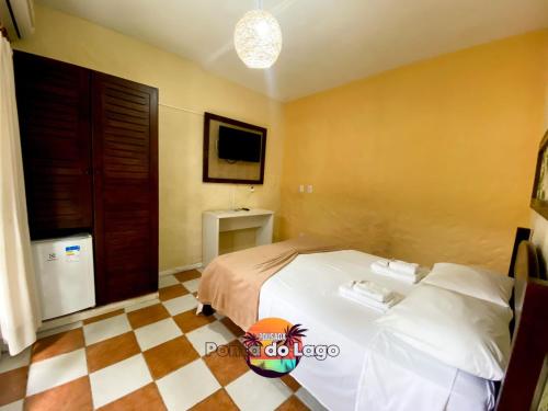 a bedroom with a white bed and a checkered floor at Pousada Ponta do Lago in Florianópolis