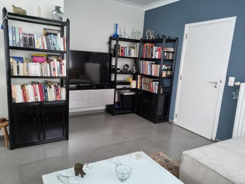 a living room with two book shelves filled with books at Magnifique appartement- Brussels expo Laeken in Brussels