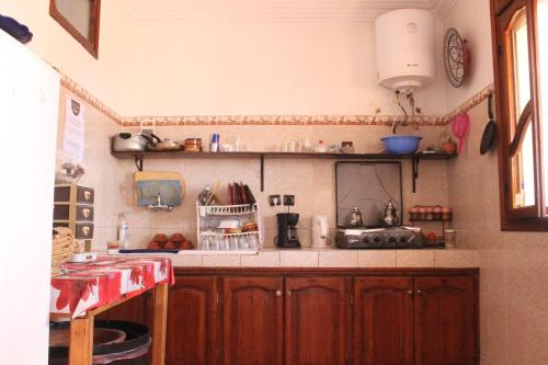 a kitchen with wooden cabinets and a counter top at Tamraght White Hostel in Tamraght Ouzdar
