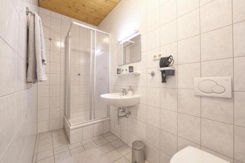 a white bathroom with a sink and a shower at Xeis NeSt in Admont