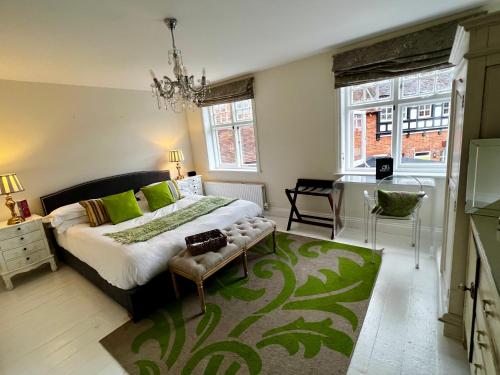 a bedroom with a bed and a table and windows at The Miller of Mansfield in Goring