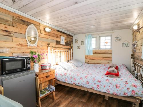 a bedroom with a bed and a tv in it at Ketburn Shepherds Hut at Balnab Farm in Newton Stewart