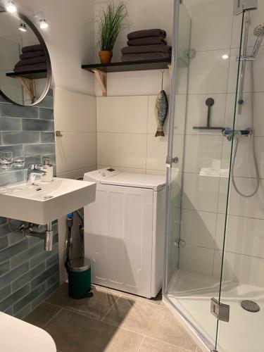 a bathroom with a glass shower and a sink at Ferienwohnung am Südstrand auf Fehmarn, Hafenblick in Fehmarn