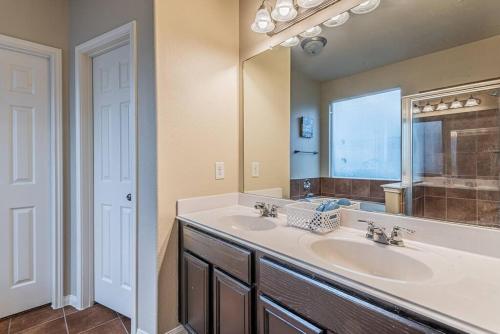 a bathroom with two sinks and a large mirror at New Beautiful 4/BR Vacation Home in Katy