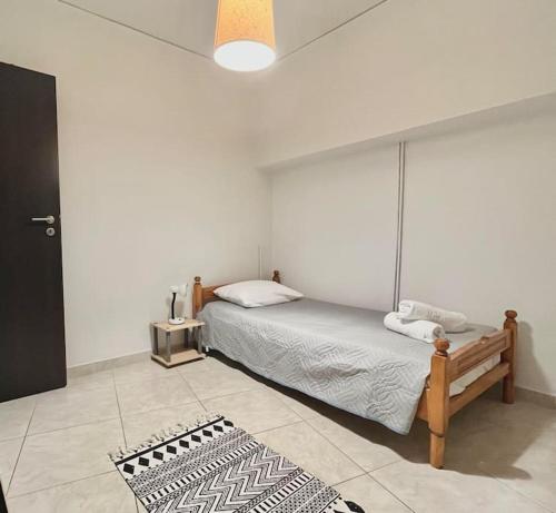sypialnia z łóżkiem i czarno-białym dywanem w obiekcie YOU Home apartment w Heraklionie
