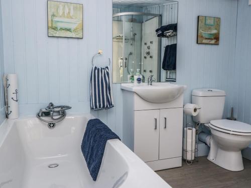 ein Badezimmer mit einer Badewanne, einem Waschbecken und einem WC in der Unterkunft The Old School Bike Shed in Stirling