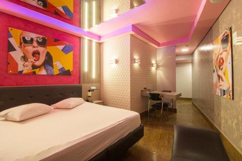 1 dormitorio con 1 cama con una pintura en la pared en Opium Motel (Adult Only), en São Paulo