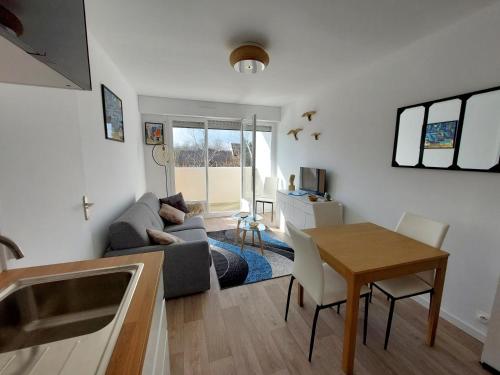 un salon avec un canapé et une table dans l'établissement Les 3 mouettes à Cabourg - côte normande, à Cabourg