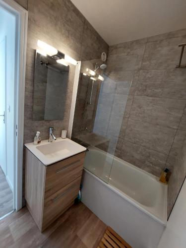 une salle de bain avec un lavabo, une baignoire et une douche dans l'établissement Les 3 mouettes à Cabourg - côte normande, à Cabourg