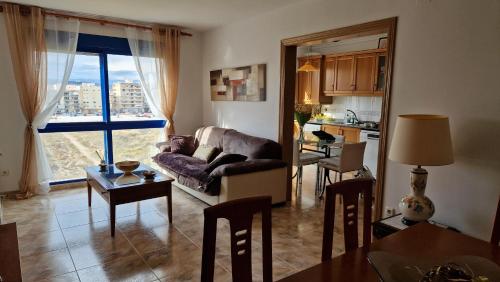 uma sala de estar com um sofá e uma mesa em Appartement vue mer près de la plage et centre ville em Vinarós