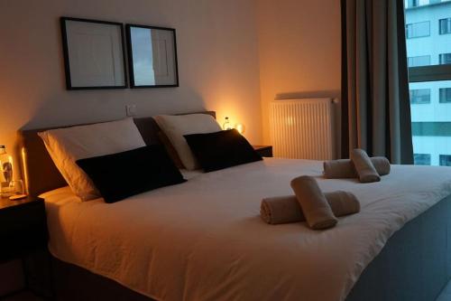 ein Schlafzimmer mit einem großen weißen Bett mit zwei Kissen in der Unterkunft Luxurious Appartment on Eilandje in Antwerpen