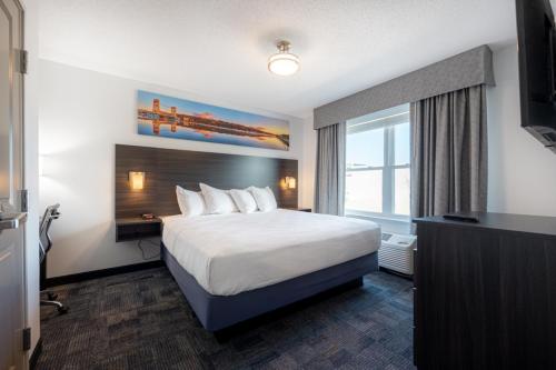 a hotel room with a bed and a large window at Independence Stay Hotel and Long term suites in Houghton