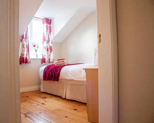 a small bedroom with a bed and a window at Kerry Holiday Homes at the Killarney Holiday Village in Killarney