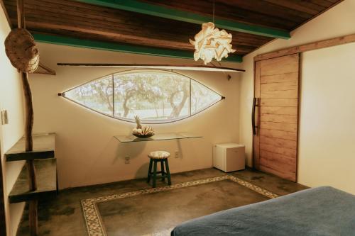 a room with a window and a bed and a table at Casa na Lagoa in Paracuru