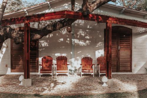 a group of chairs sitting on the porch of a house at Casa na Lagoa in Paracuru