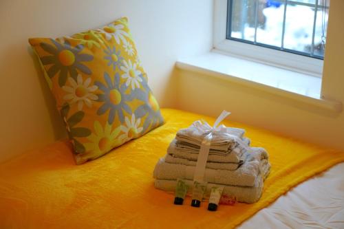a folded towel on a bed next to a pillow at Redwood in Longton