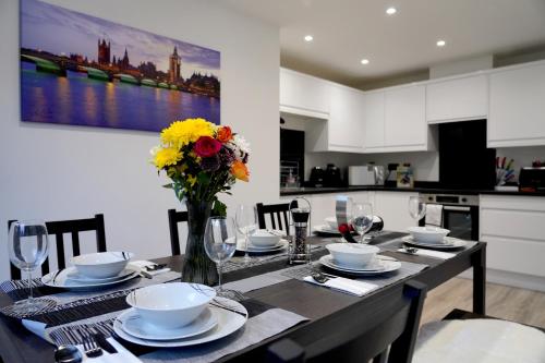 a dining room table with a vase of flowers on it at Redwood in Longton