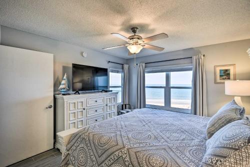 a bedroom with a bed with a ceiling fan and a television at Oceanfront Condo Rental Near Daytona Speedway in Ormond Beach