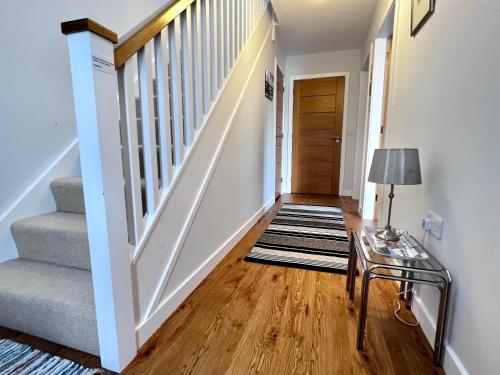 a hallway with stairs and a table with a lamp at Central Spacious 2 Bed 2 Bath, Free WiFi & Parking, Park View in Orkney
