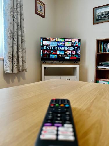 a remote control sitting on a table in front of a television at Central Spacious 2 Bed 2 Bath, Free WiFi & Parking, Park View in Orkney
