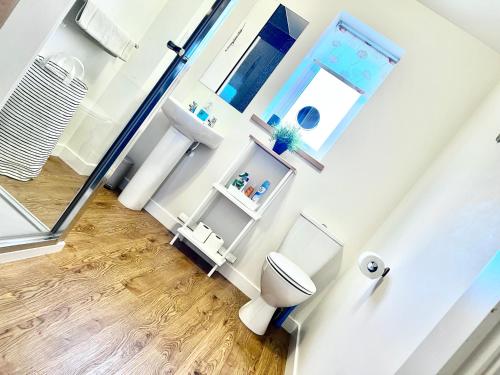 a bathroom with a toilet and some windows at Central Spacious 2 Bed 2 Bath, Free WiFi & Parking, Park View in Orkney