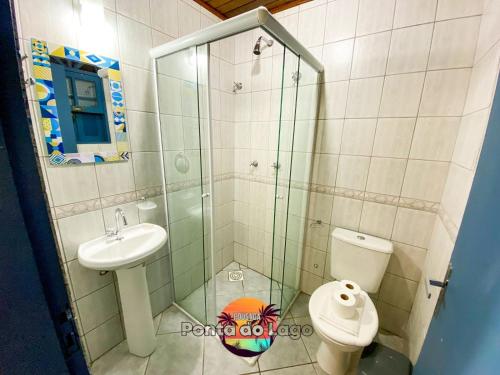 a bathroom with a shower and a toilet and a sink at Pousada Ponta do Lago in Florianópolis