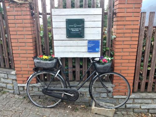 a bike parked next to a gate with flowers in baskets at Appartamento a due passi da Burcina in Favaro