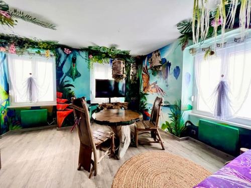 a dining room with a table in a room with tropical wallpaper at Avataar - L'arbre de Pandoraa in Belfort