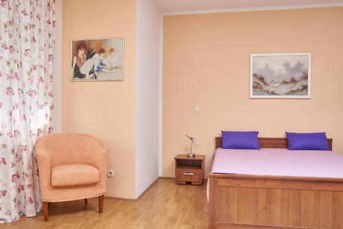 sypialnia z łóżkiem i krzesłem w obiekcie Apartments Lovric with sea view w mieście Kaštela