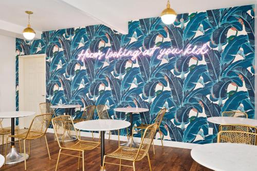 a room with tables and chairs and a wall with a mural at Casablanca Inn in San Clemente