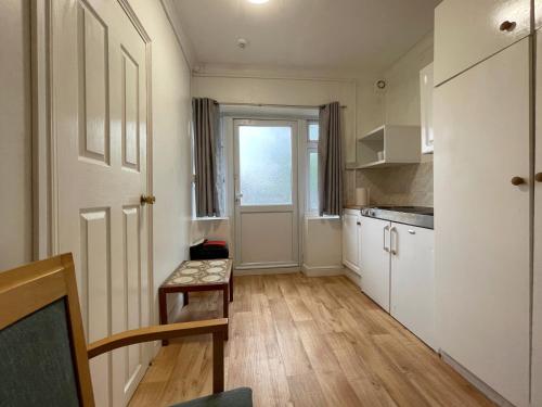 a small kitchen with white cabinets and a window at Luxury Suites near Wembley Stadium, Wembley Arena, London Designer Outlet in London