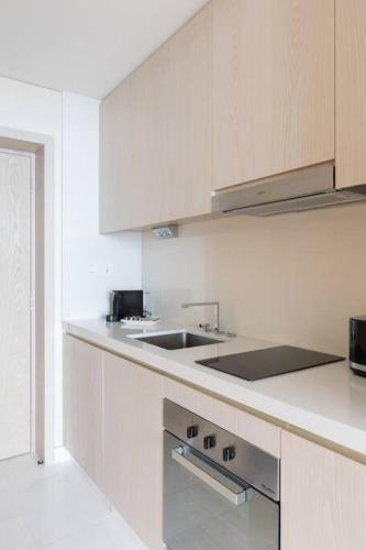 a white kitchen with a sink and a counter at Palm Tower St. Regis Amazing view high-end Studio in Dubai