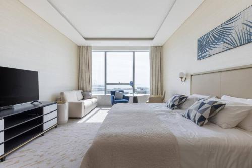 a hotel room with a large bed and a television at Palm Tower St. Regis Amazing view high-end Studio in Dubai