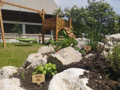 een tuin met rotsen en een bank in een tuin bij Alpine Joy Apartments in Bohinj