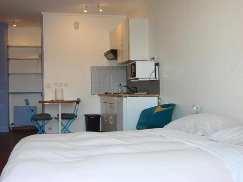 sypialnia z białym łóżkiem i kuchnią w obiekcie ACCI Cannes Les Yuccas w Cannes