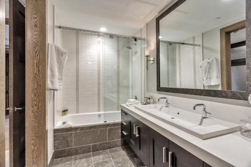 a bathroom with a sink and a tub and a mirror at Stein Eriksen Residences in Park City