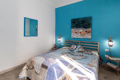 1 dormitorio con paredes azules y 1 cama en SyracuseApartments IL PASUBIO di SIRACUSA Stupendo appartamento vicino ad ORTIGIA a 200m dal MARE, en Siracusa