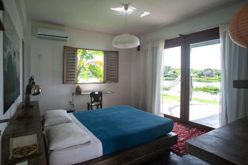 a bedroom with a bed and a window and a table at Casa na Lagoa in Paracuru