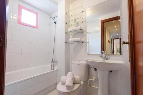 La salle de bains blanche est pourvue d'un lavabo et de toilettes. dans l'établissement Apartamento increíbles vistas primera línea de playa para familias, à Calp